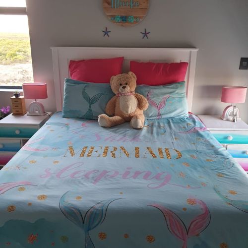 Bedroom with mermaid-themed bedding and teddy bear