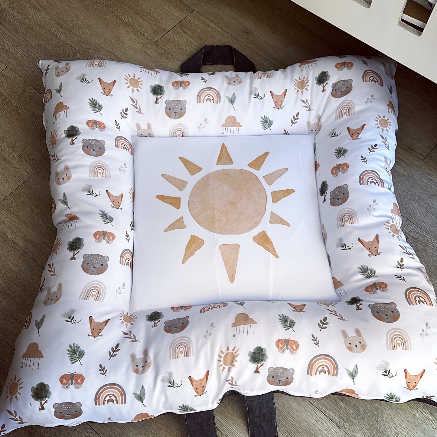 A play doughnut with a boho sun design and various playful patterns, including animals and rainbows, with a white background.