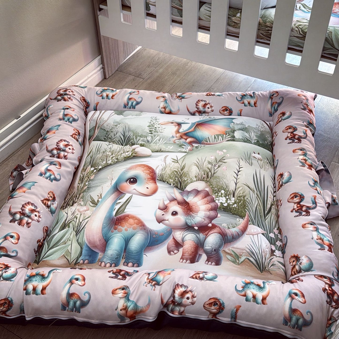Children's dinosaur-themed bedding set in a crib.