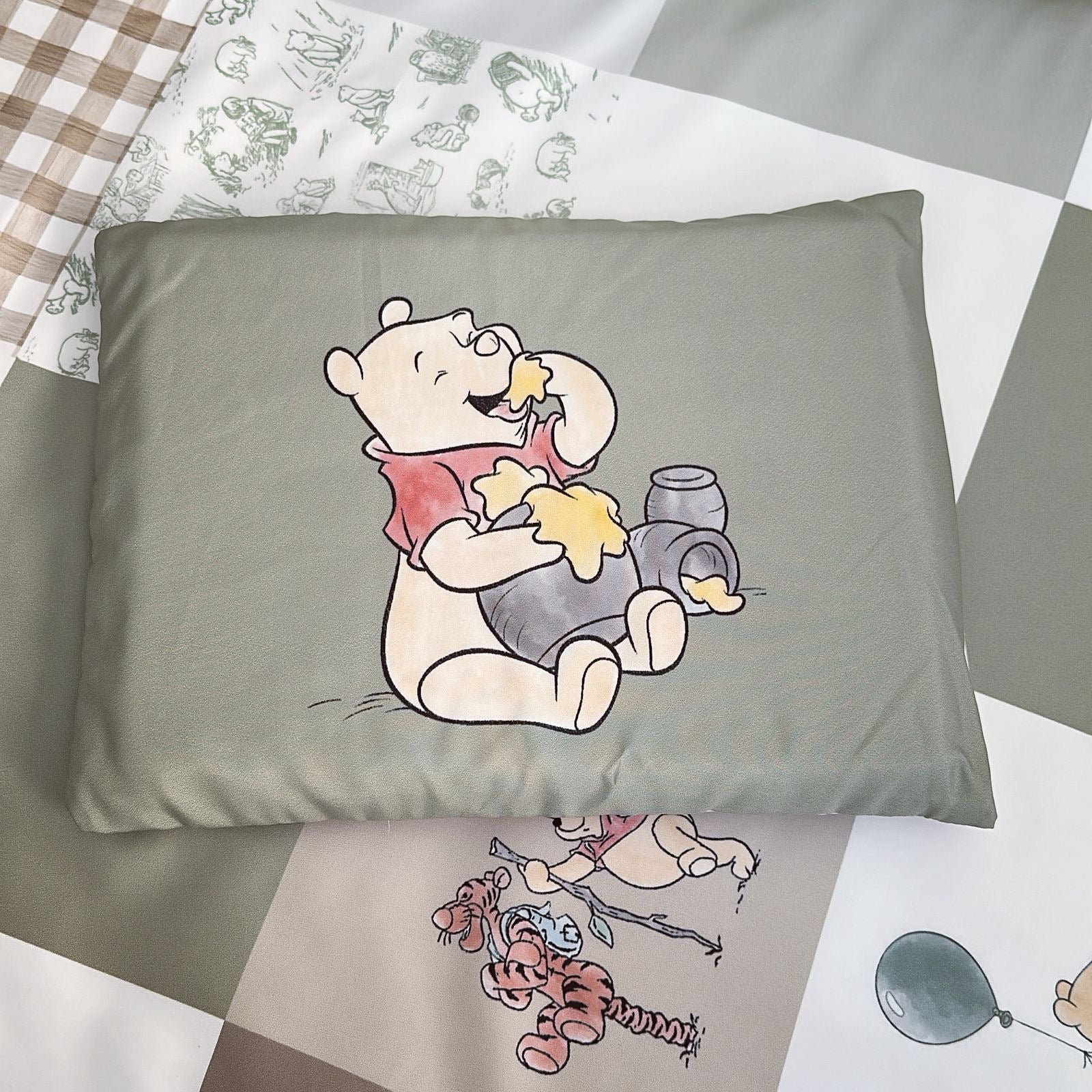 Gray pillowcase with Winnie the Pooh design on a checkered fabric background