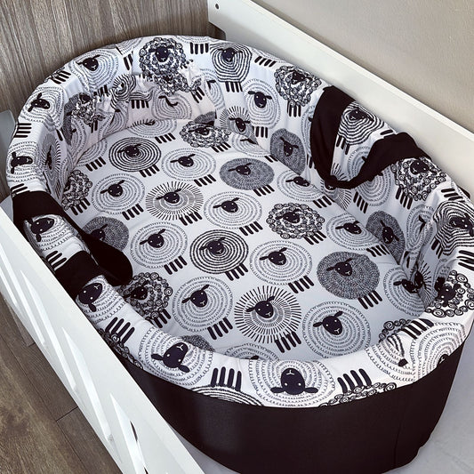 Baby bassinet with black and white patterned cover