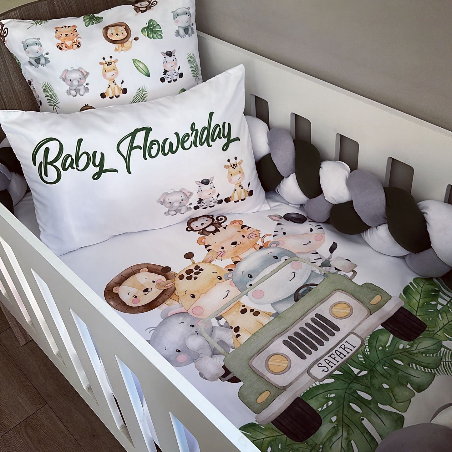 Crib with safari-themed bedding, pillows, and bumper