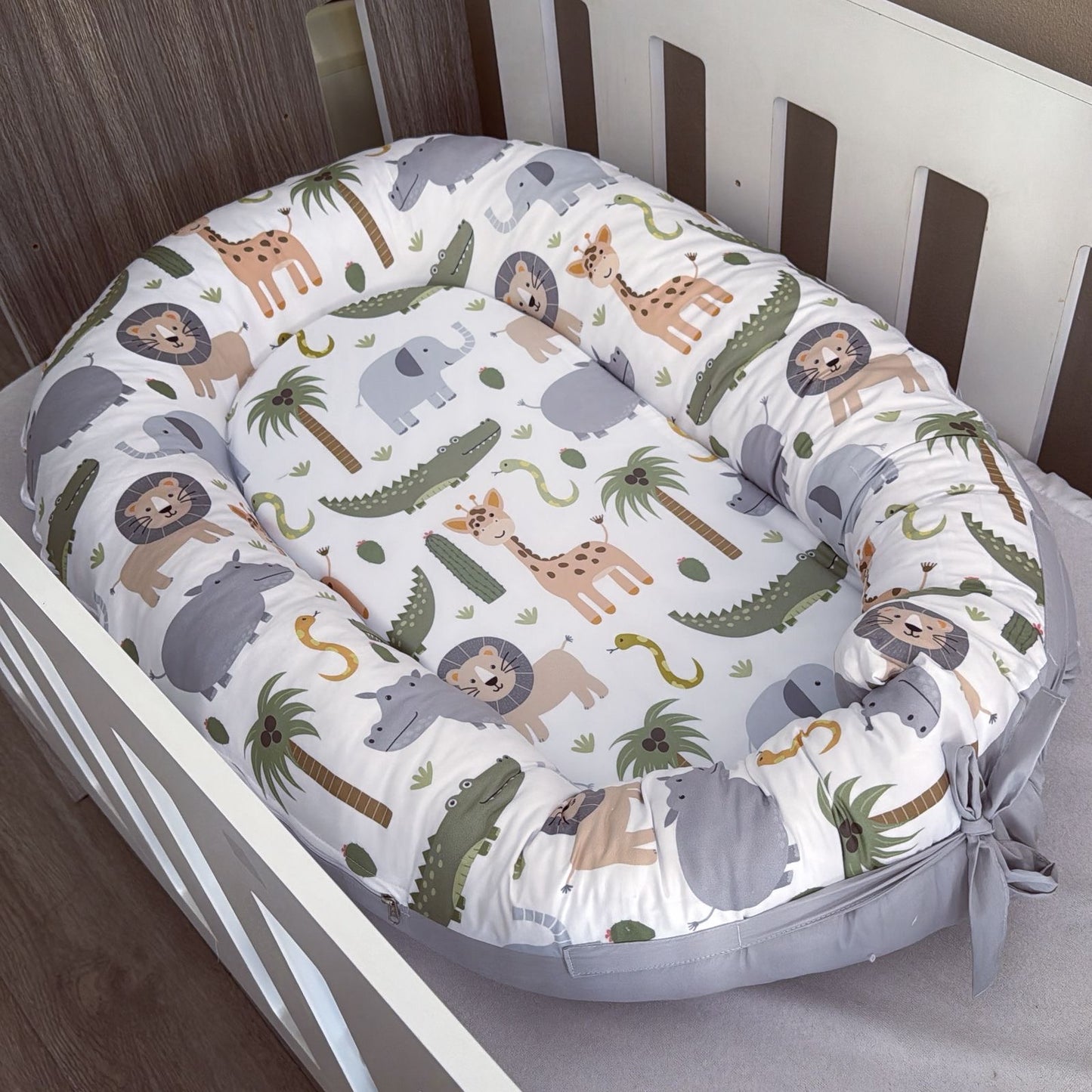 Baby nest with animal pattern in a crib
