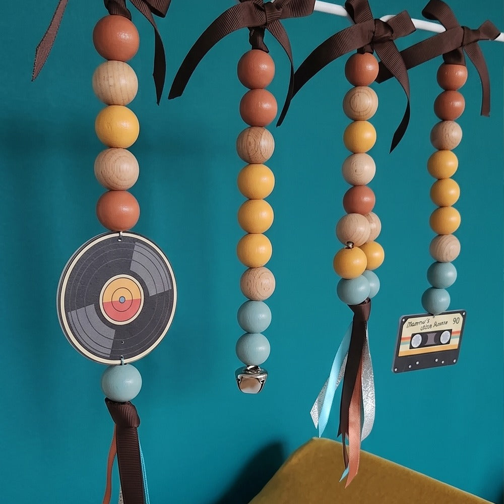 Decorative hanging items with beads and record design against a teal background