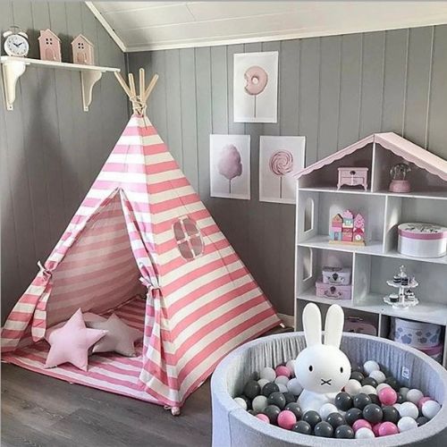 Children's room with pink and white striped teepee, ball pit, and shelves.