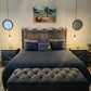Bedroom with wooden headboard, blue bedding, and decorative pillows.