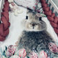 Floral-patterned blanket with a rabbit design on a crib