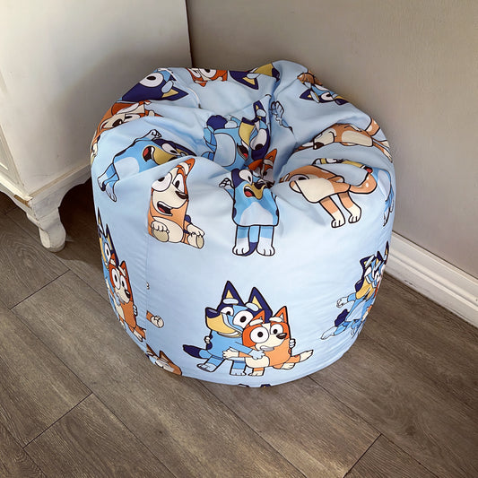 A round beanbag chair with a printed design featuring cartoon characters on a blue background.