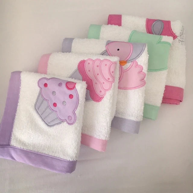 Set of children's Burp Cloths towels with cupcake and duck designs on a light background