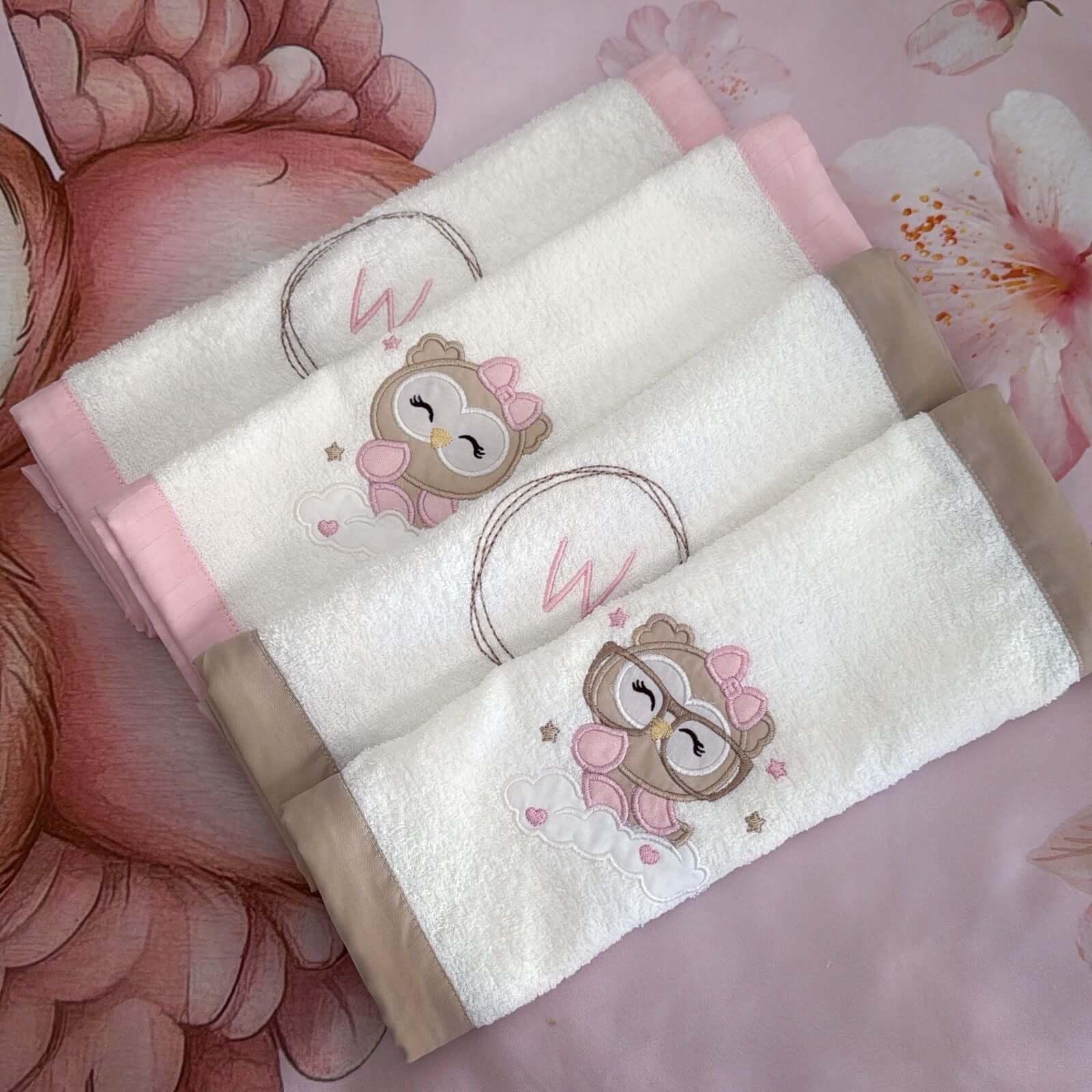 White towels with cartoon owl designs on a floral background