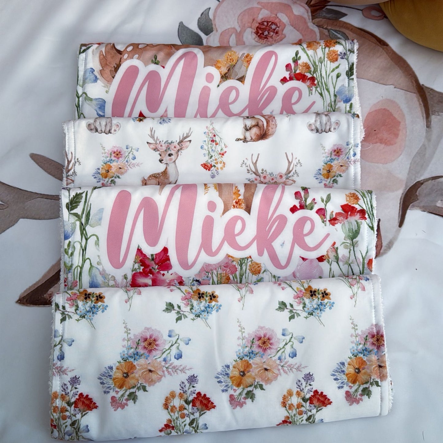 Stack of fabric swatches with floral and animal patterns, featuring the name 'Wlieke'.