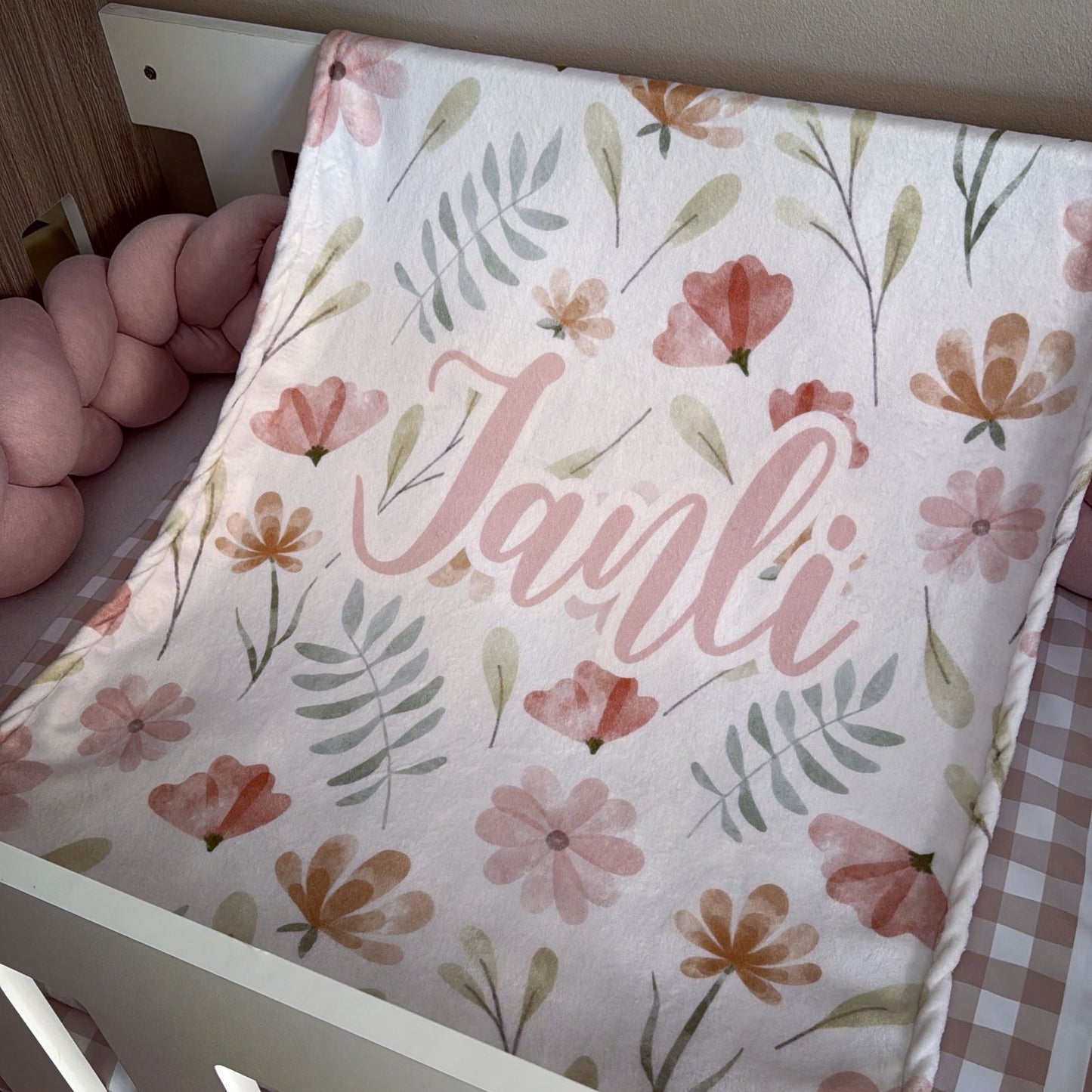 Floral-patterned pouch with 'Janli' branding held by a hand.