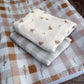 Stack of folded fabric sheets with bird pattern on a checkered fabric background | All Nursery Sets | Baby Bedding Sets South Africa | Soft Spot Kids | South Africa