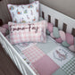 A baby bedding set styled in a white crib, featuring a pink and white gingham patchwork quilt, matching pillows with bunny illustrations and the personalized name 'Emma-Fay' in script, a green gingham pillow, and a pink and green bubble bumper. | All Nursery Sets | Baby Bedding Sets South Africa | Soft Spot Kids | South Africa