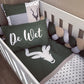 Crib with green bedding featuring a deer design and 'De Wet' text, surrounded by decorative elements. | All Nursery Sets | Baby Bedding Sets South Africa | Soft Spot Kids | South Africa