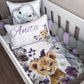 Customizable baby bedding set in a white crib, featuring a watercolor print of an elephant, zebra, lion cub, and purple flowers. Includes a white crib bumper with lavender and gray beads, a personalized pillow reading 'Anita' in purple script, and a matching elephant pillow. | All Nursery Sets | Baby Bedding Sets South Africa | Soft Spot Kids | South Africa