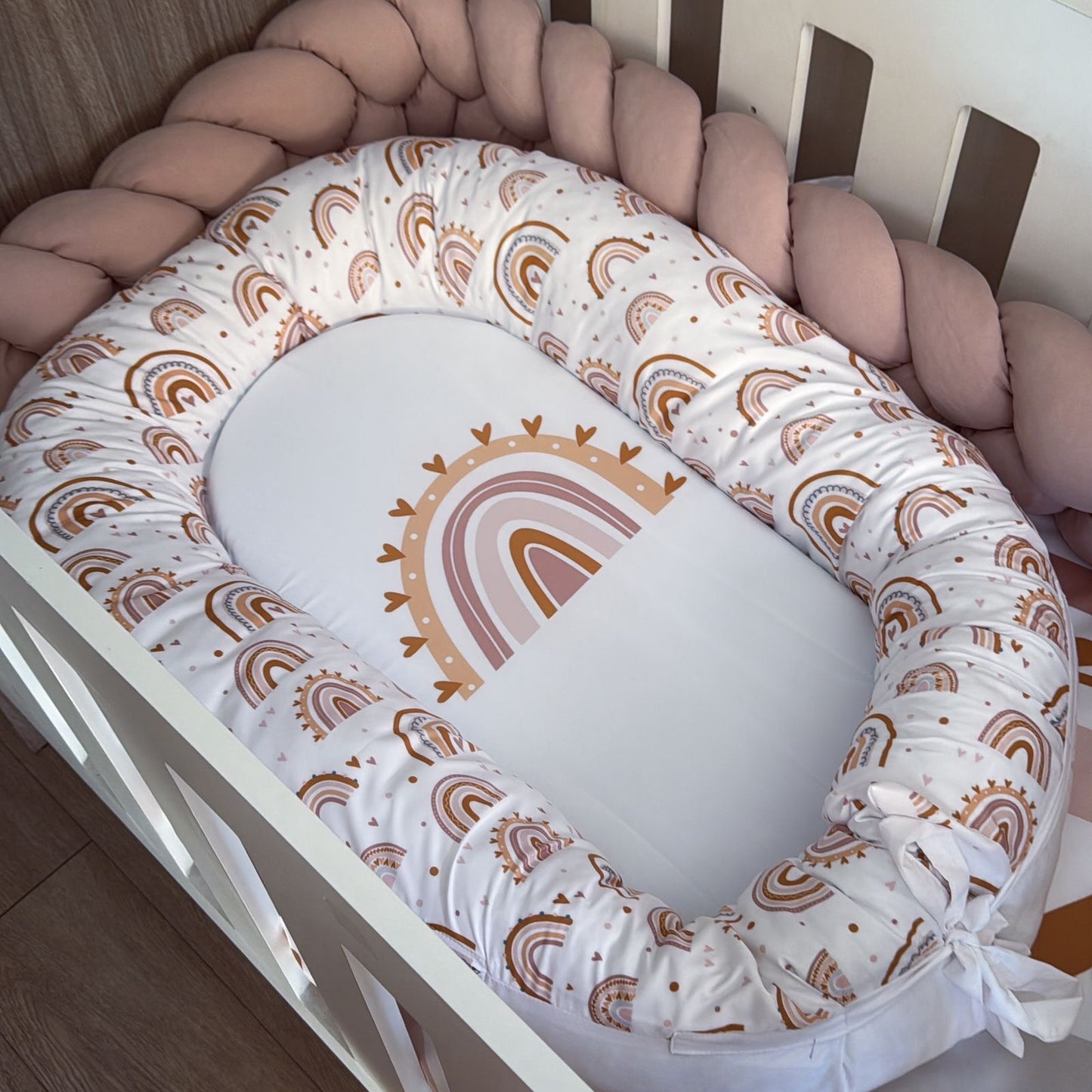 Baby crib bumper with rainbow pattern in a crib
