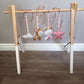 Wooden baby gym with hanging toys on a wooden floor. | All Nursery Sets | Baby Bedding Sets South Africa | Soft Spot Kids | South Africa