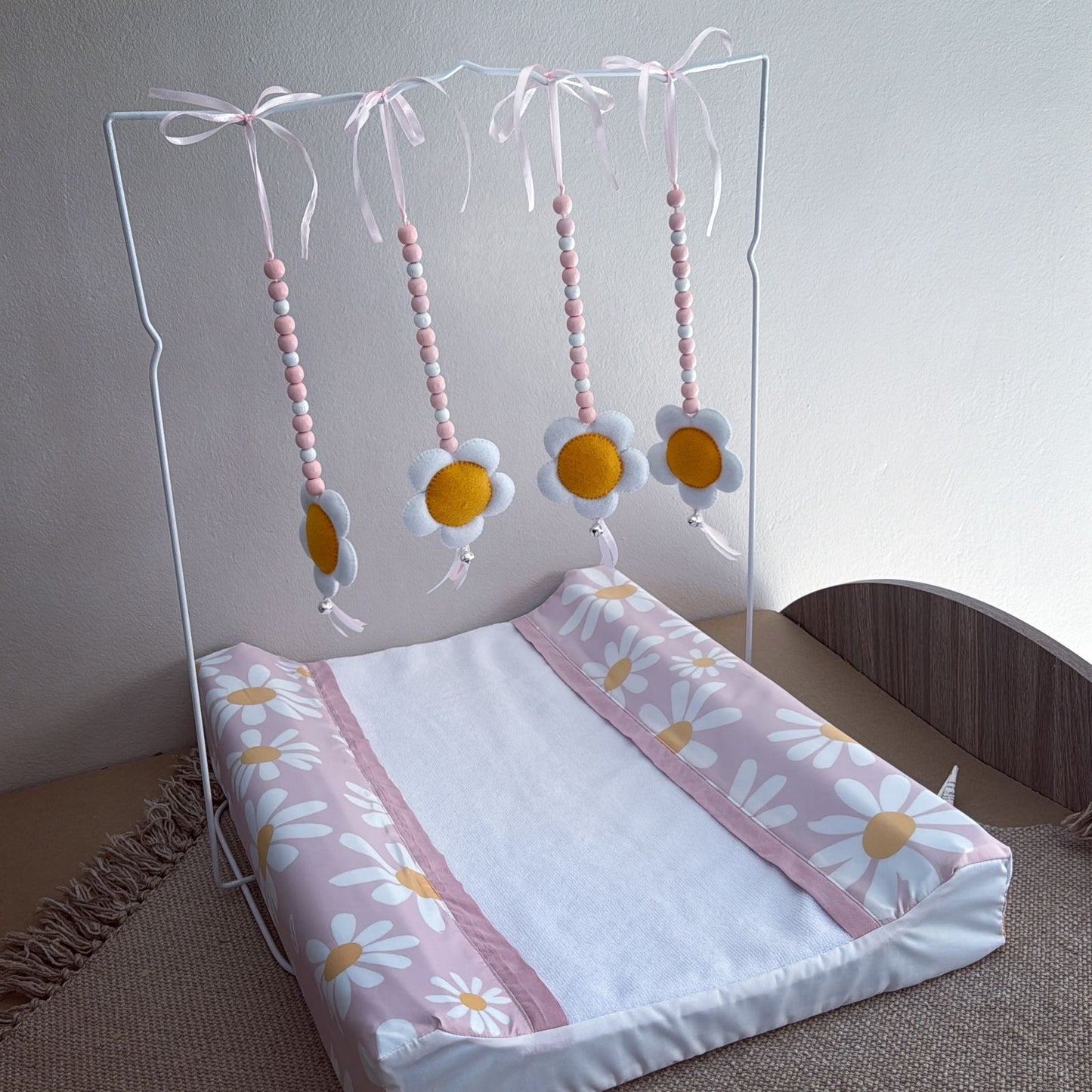 Baby crib with floral bedding and mobile on a neutral background