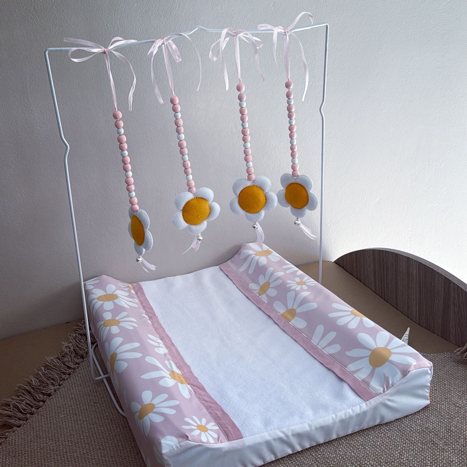 Baby crib with floral bedding and mobile on a neutral background