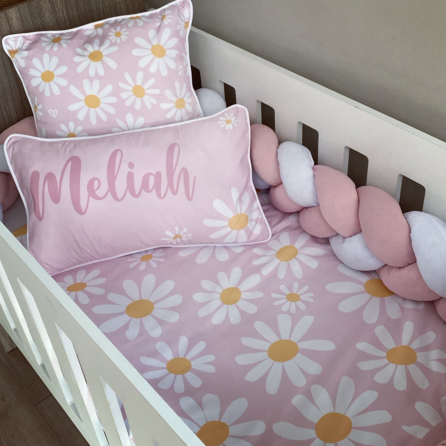 Crib with pink floral bedding and 'Meliah' pillow