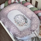 Floral-patterned baby crib bumper with decorative pillow on a wooden floor. | All Nursery Sets | Baby Bedding Sets South Africa | Soft Spot Kids | South Africa
