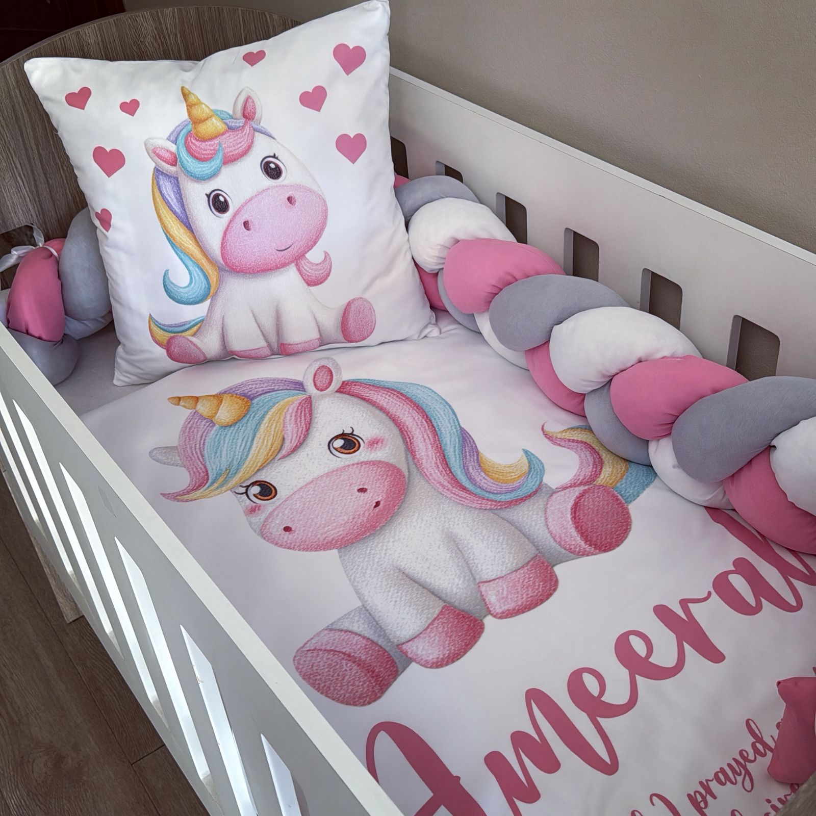 Children's crib with unicorn-themed bedding and pillow