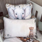 Two decorative pillows displayed on a bed in a nursery setting. The front pillow is off-white with a cute cheetah illustration and gray-green piping, while the back pillow features a large watercolor-style baby elephant with a patterned border. | All Nursery Sets | Baby Bedding Sets South Africa | Soft Spot Kids | South Africa