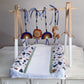 A baby changing pad with a wooden hanging toy bar, featuring colorful animal and rainbow toys, displayed on a white dresser against a neutral gray wall. | All Nursery Sets | Baby Bedding Sets South Africa | Soft Spot Kids | South Africa