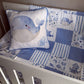 A blue and white whale-themed crib bedding set including a patchwork quilt, matching crib bumper, and a decorative whale pillow, shown inside a white wooden crib. | All Nursery Sets | Baby Bedding Sets South Africa | Soft Spot Kids | South Africa