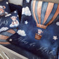 A cozy children's bedding set featuring a dark blue space-themed blanket and matching pillows with a watercolor hot air balloon, teddy bear, clouds, stars, and the personalized name 'Købus de Klerk' in white script. | All Nursery Sets | Baby Bedding Sets South Africa | Soft Spot Kids | South Africa