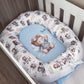 A baby crib bedding set featuring a white bassinet bumper pad with a brown teddy bear and airplane pattern, surrounding a light blue oval mattress topper with a matching teddy bear illustration. | All Nursery Sets | Baby Bedding Sets South Africa | Soft Spot Kids | South Africa