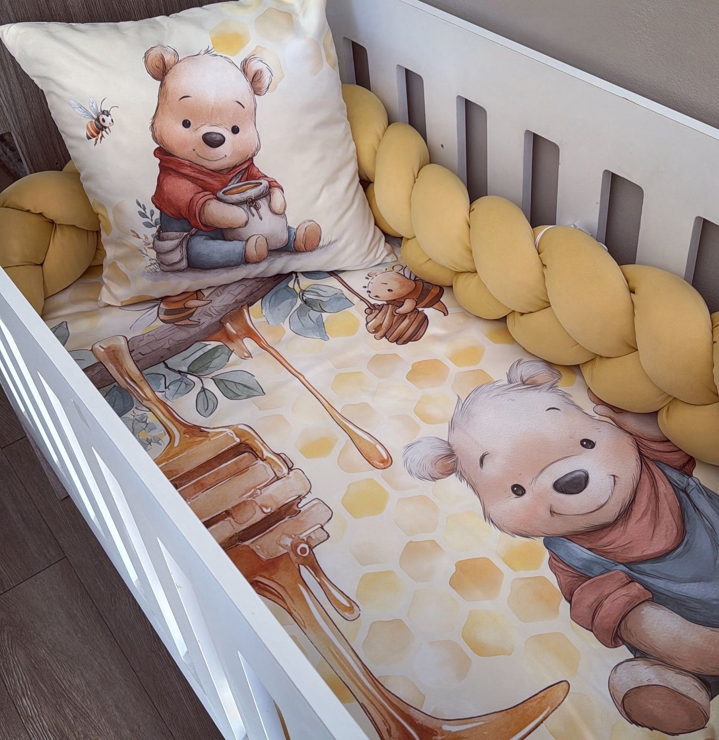 Baby crib with Winnie the Pooh-themed bedding and pillow