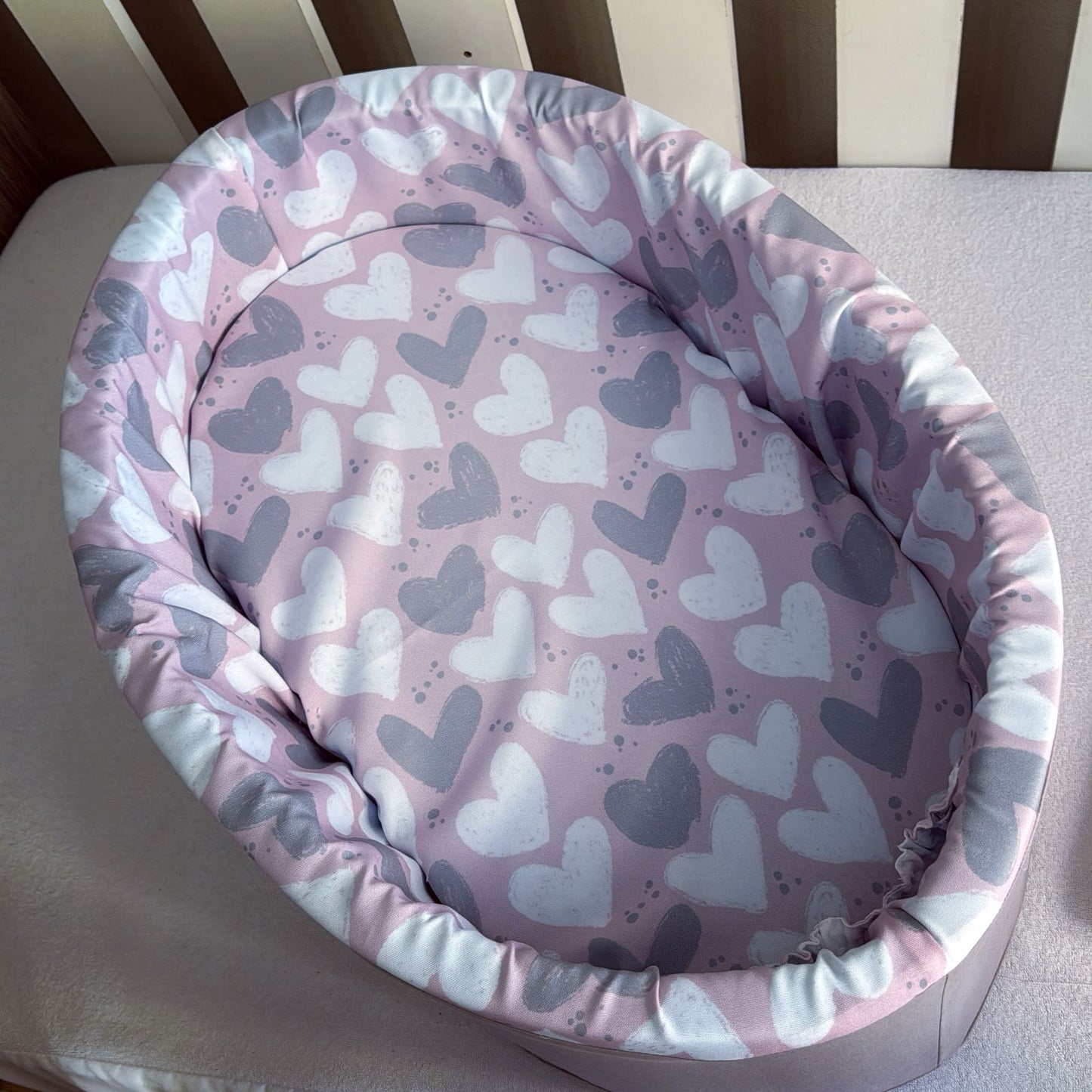 Baby seat cover with heart pattern on a striped background