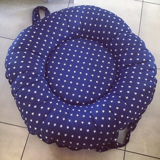 Blue cushion with white star pattern on a tiled floor