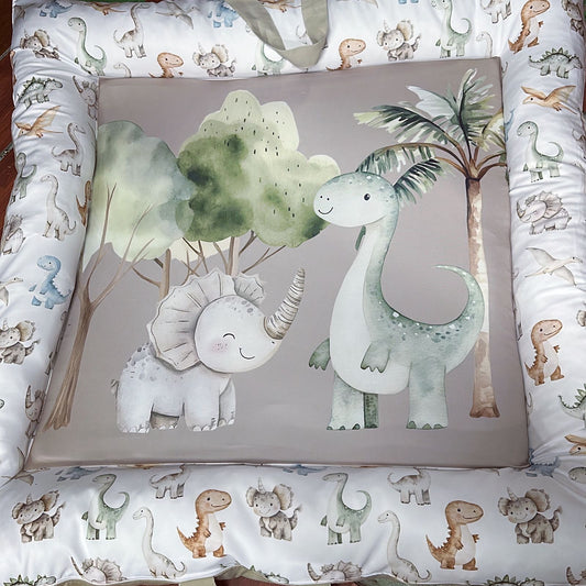 Baby crib bumper with dinosaur illustrations on a patterned background