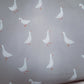 Light gray wallpaper featuring a repeating pattern of white geese with orange beaks and legs. | Baby Doughnut Cushions | Infant Support Pillows | Soft Spot Kids | South Africa