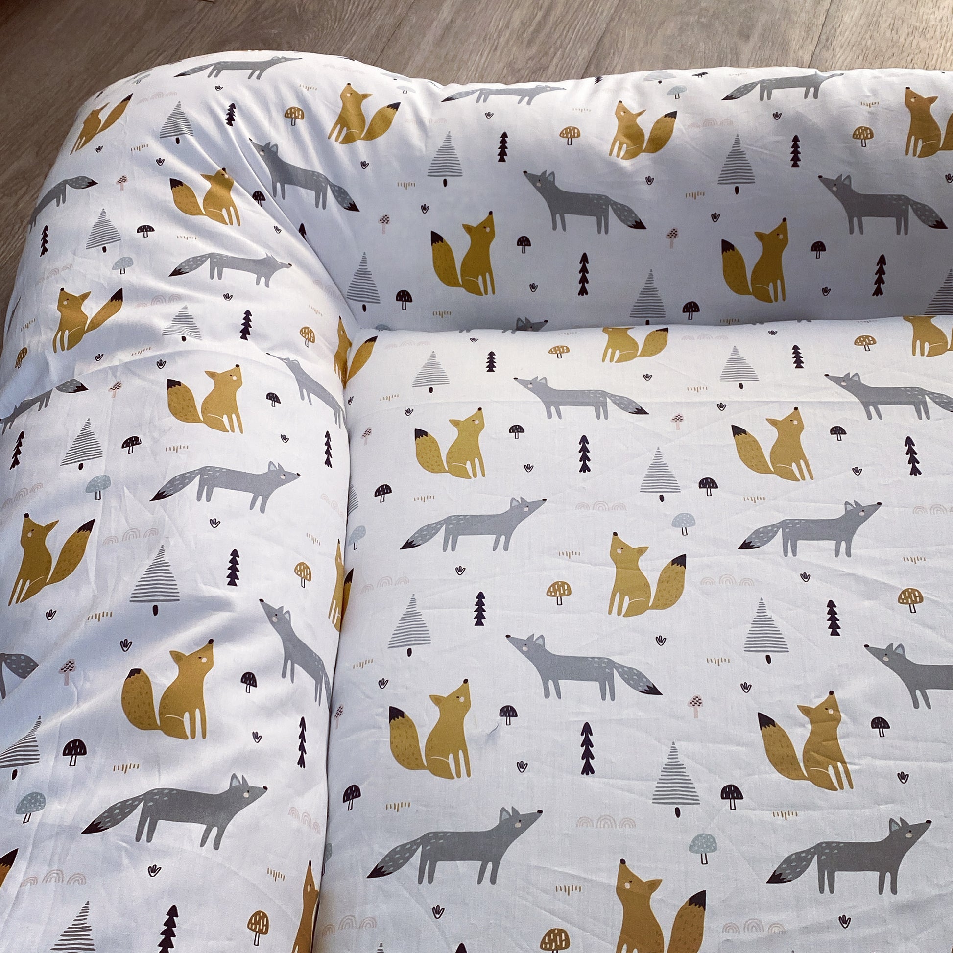 Baby Doughnut - Woodlands 01with fox pattern on a wooden floor