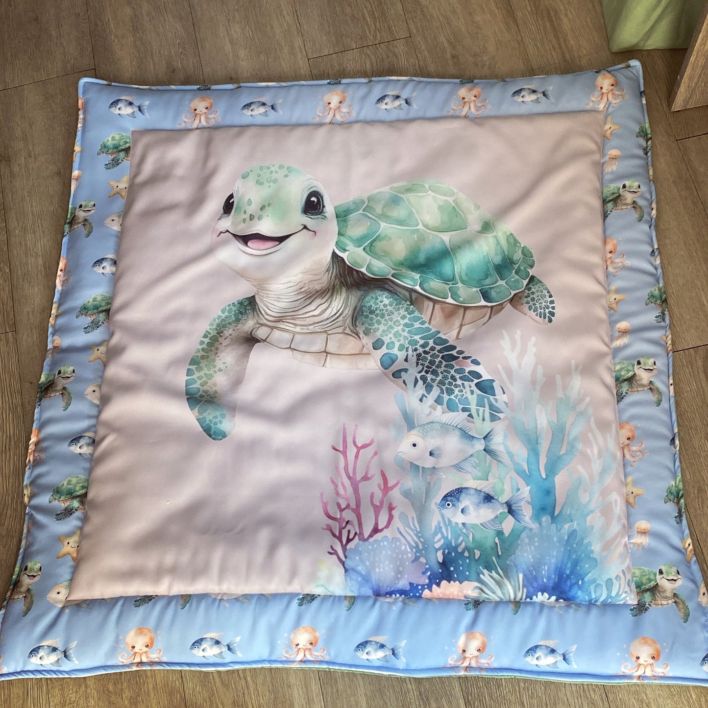 Children's play mat with a turtle design on a wooden floor