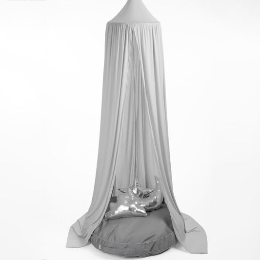 A grey hanging tent canopy with a hoop diameter of 45cm, displayed outdoors. It appears to be made of a stretchy fabric and is draped elegantly with one side featuring a metallic ornament.