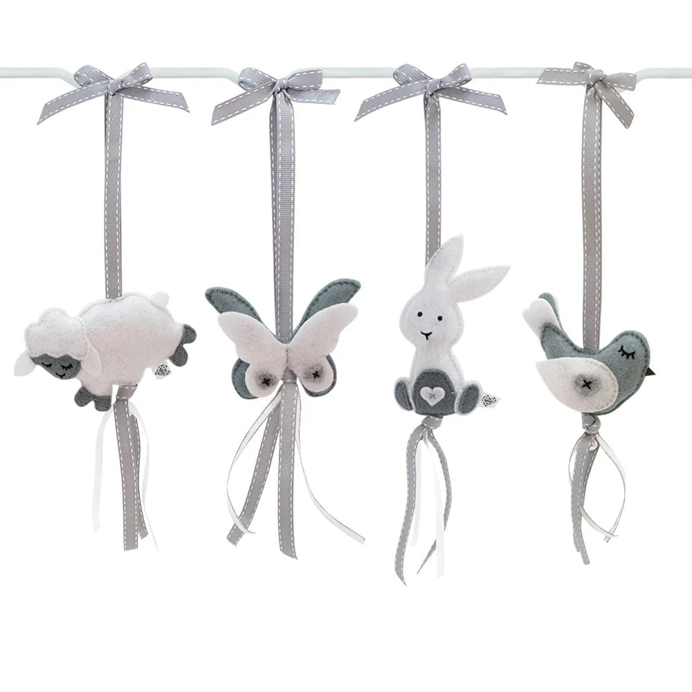 A set of four soft fabric nursery hanging ornaments on a white rod, including a sheep, butterfly, bunny, and bird, in white, gray, and dark gray colors.