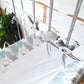 A baby crib bedding set featuring a white fitted sheet and matching cloud-patterned crib bumper and headboard cover in gray and light blue, with a gray and white plush bird mobile hanging above. | Baby Essentials | All Baby Products | Soft Spot Kids | South Africa