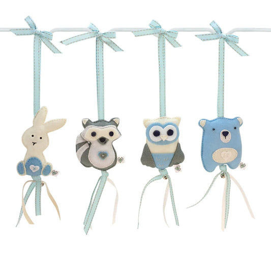 Four fabric animal hanging ornaments on a white bar with light blue ribbons: a bunny, raccoon, owl, and bear, shown on a plain white background.