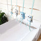 A soft baby crib hanging toy set with four plush animal figures suspended by mint blue ribbons. The figures include a white rabbit, a gray wolf, a light blue bear, and a blue-and-white owl, arranged on a white crib against a white rustic wood wall. | Baby Essentials | All Baby Products | Soft Spot Kids | South Africa