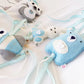 A set of soft felt baby keepsakes or tags shaped like animals, including a blue bear, a white bunny, and a gray-and-white owl, attached to pale blue ribbons on a white fabric background. | Baby Essentials | All Baby Products | Soft Spot Kids | South Africa