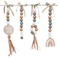 Four boho-style beaded baby wall hangings suspended from a metal rod with beige ribbon bows. The set includes a circular tag reading 'Here comes THE SUN,' a bell bead, a wood-and-white beaded strand with orange ribbon tassels, and a wooden rainbow charm. | Baby Essentials | All Baby Products | Soft Spot Kids | South Africa