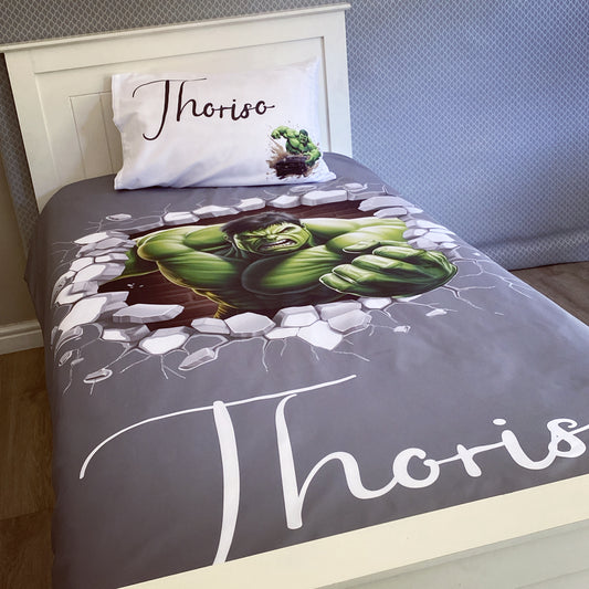 A toddler bedding set with a character illustration of Hulk on a gray background, with the name 'Thor' written on the bedspread.