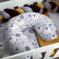 Gray U-shaped pillow with animal pattern on a white crib