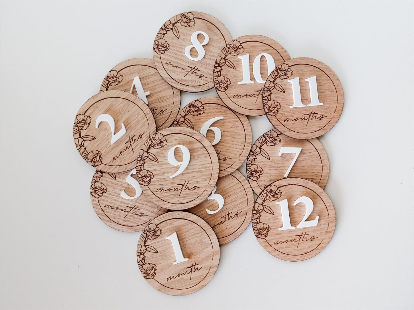 Wooden milestone discs with numbers on a light gray background