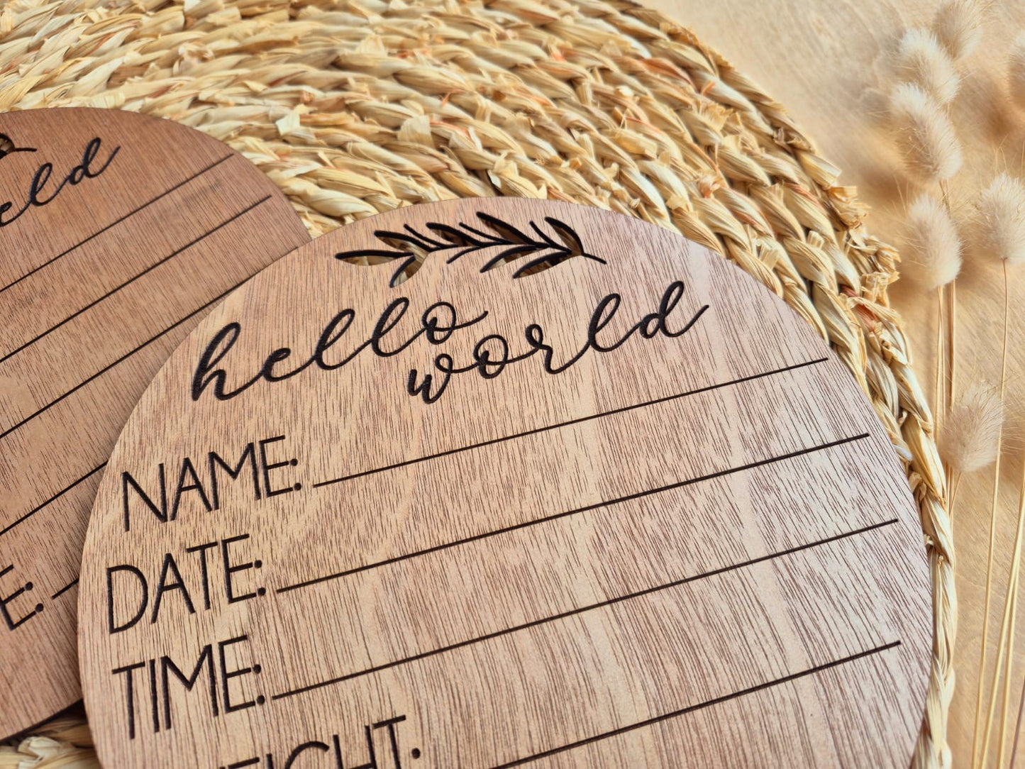 Wooden round card with 'hello world' and fill-in-the-blank sections on a woven mat background.